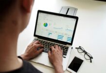KCCI rises 11.88% as container freight rates strengthen a person writing in front of a laptop and he is working for an index prices