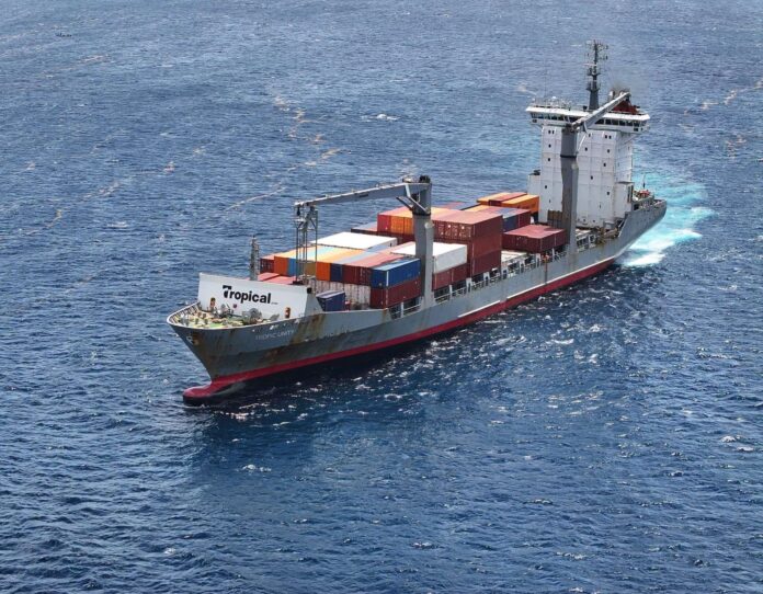 Tropical Shipping container vessel Tropic Unity sailing at sea with containers loaded on deck.