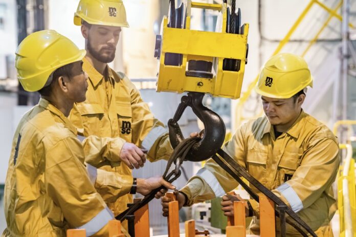 MSC crew members handling lifting equipment aboard a vessel.