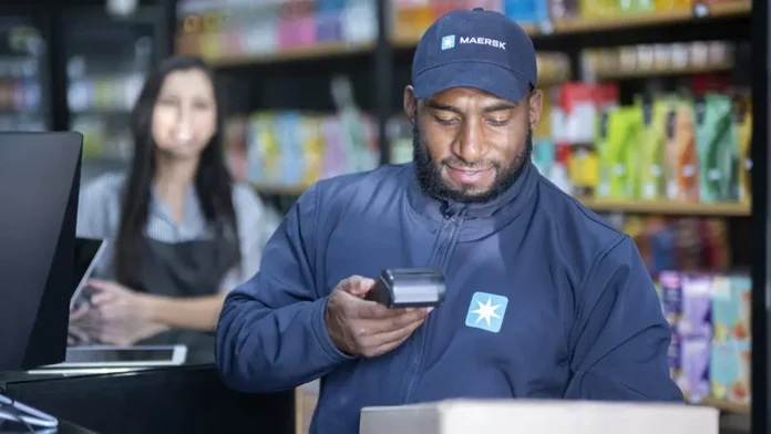 Maersk delivery worker scans a parcel inside a retail store as part of an e-commerce delivery operation.
